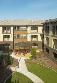 Apartment complex with a courtyard and seating area.