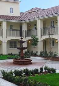 A courtyard with a fountain in front of a building.