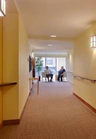 A hallway with people sitting at a table in the distance.