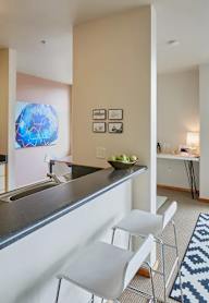 A kitchen with a blue and white patterned rug on the floor.