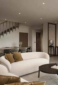 A white couch with brown pillows sits in a modern living room.