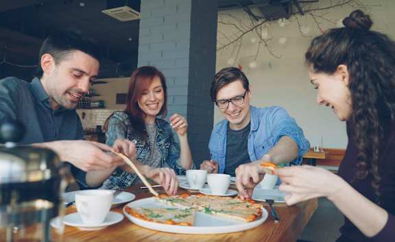 Four people enjoying a meal together at a table.