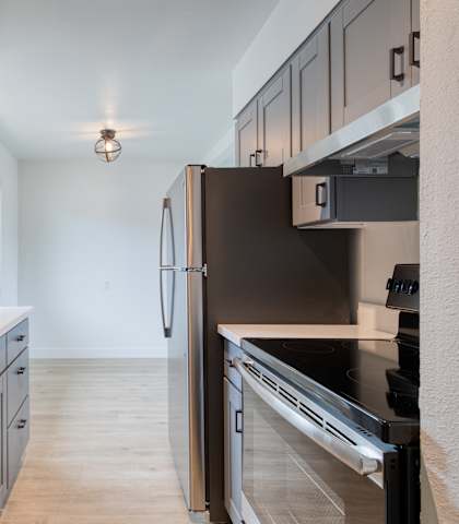 a kitchen with white countertops and gray cabinets