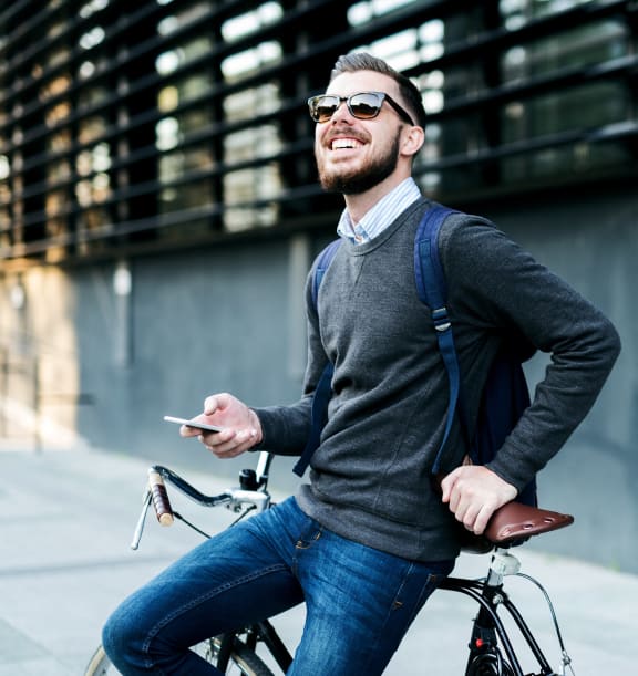 a man riding a bike while holding a cell phone