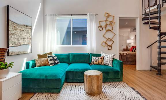 a living room with a green couch and a white rug