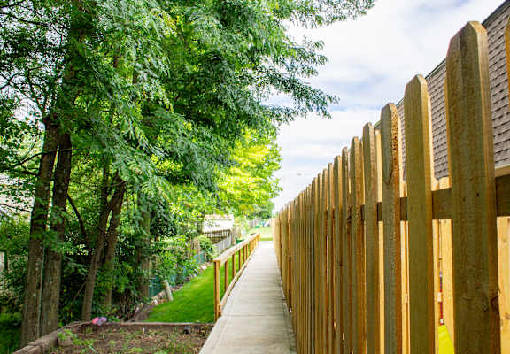 A wooden fence runs along the side of a walkway.