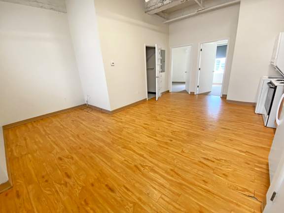 A room with wooden flooring and white walls.