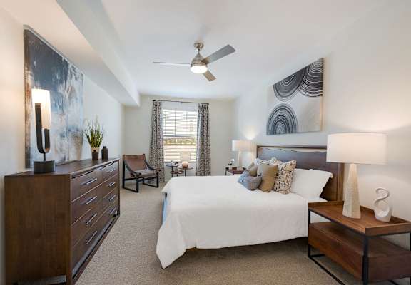 a bedroom with a large bed and a ceiling fan