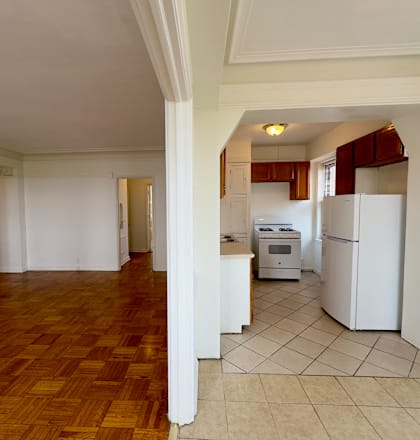 a view of a kitchen and a living room with white appliances