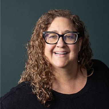 a woman wearing glasses and a black shirt
