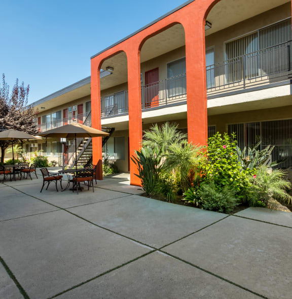a courtyard with tables and chairs outside of a building