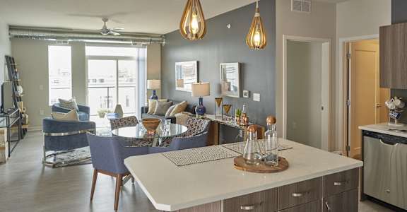 A modern kitchen with a dining area and a living room.