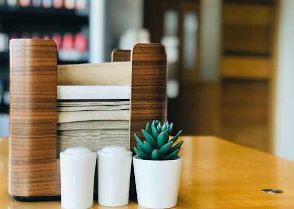 A white table with two blue bottles and a white and blue vase on it.