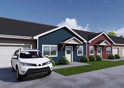A white car is parked in front of a blue house.