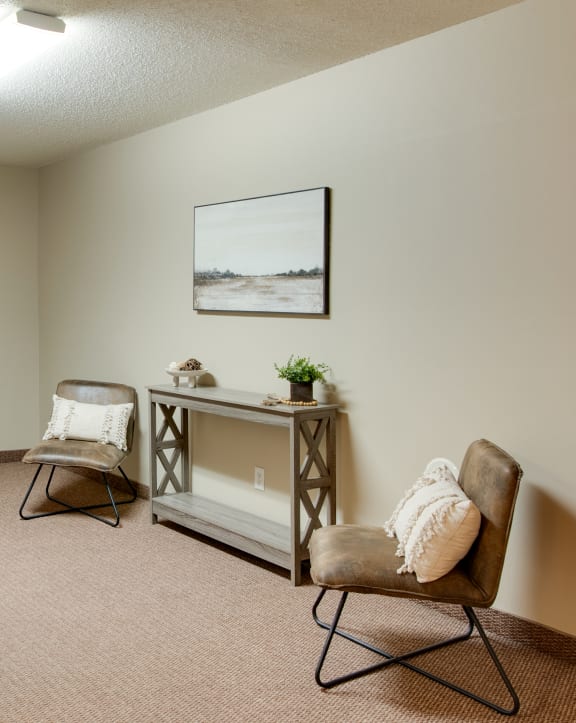 a living room with two chairs and a table and a door
