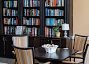 Thumbnail 6 of 17 - A room with a table, chairs and a bookshelf.