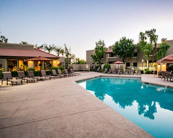 a swimming pool with chairs and umbrellas at the resort