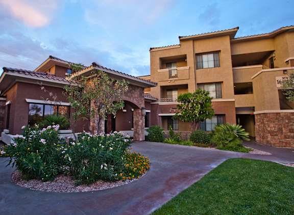 a building with a driveway and landscaping in front of it