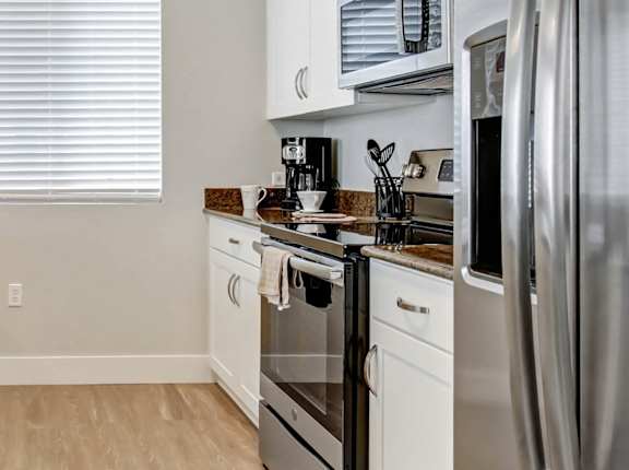 A kitchen with white cabinets and a granite countertop. at Apex Mission Valley, California, 92108