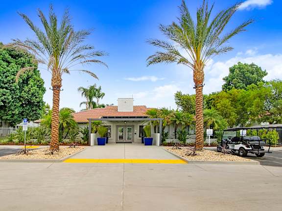 a parking lot with palm trees in front of a building at The Park Apartments, Rancho Cucamonga, CA