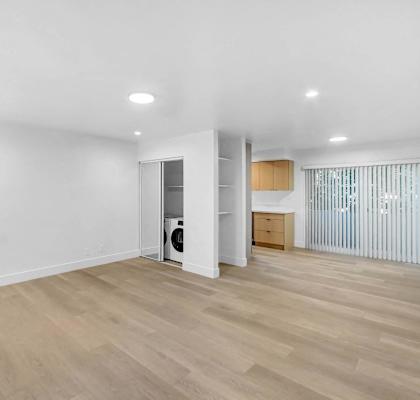 a living room with white walls and a wood floor