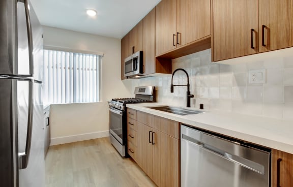 a kitchen with wooden cabinets and white countertops