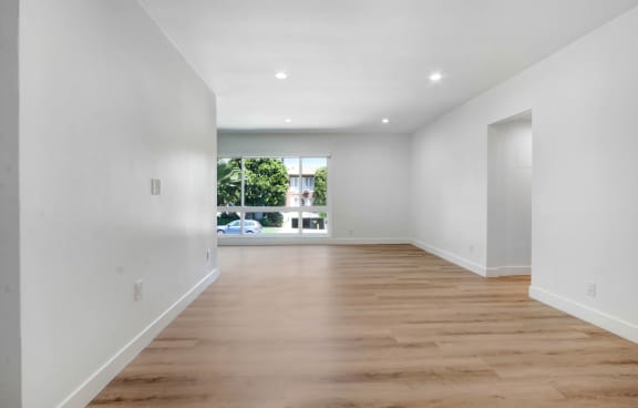 a bedroom with hardwood floors and white walls