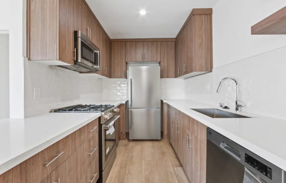 a kitchen with white countertops and wooden cabinets
