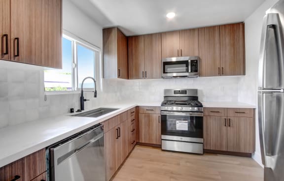 a kitchen with wooden cabinets and stainless steel appliances
