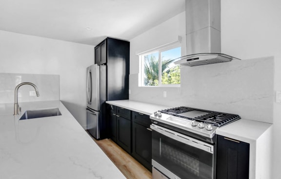 a kitchen with white counter tops and black appliances