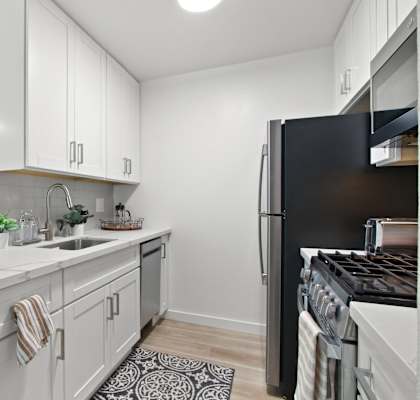 a kitchen with white cabinetry and black appliances