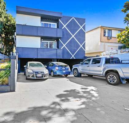 a blue and white building with cars parked in front of it