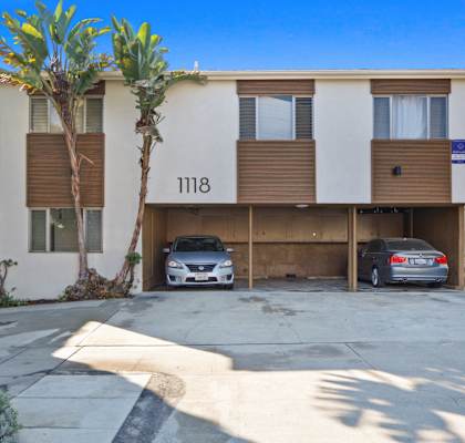 a condo with two cars parked in front of it