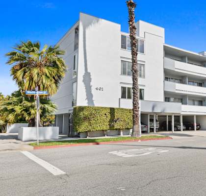 a white building with palm trees in front of it