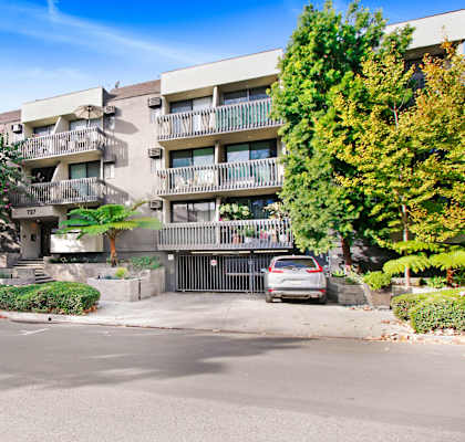 an apartment building with cars parked in front of it