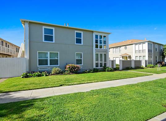 A row of houses with a clear blue sky above them.