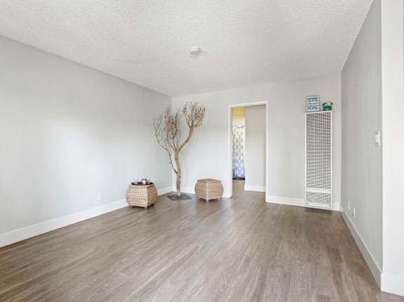 A room with wooden floors and white walls  at Clair Del and Clair Del Gardens, Long Beach