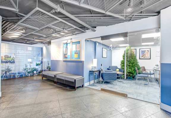 a lobby with couches and tables and a glass door at Atrium, Los Angeles, CA