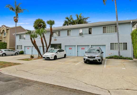 a white building with two cars parked in front of it