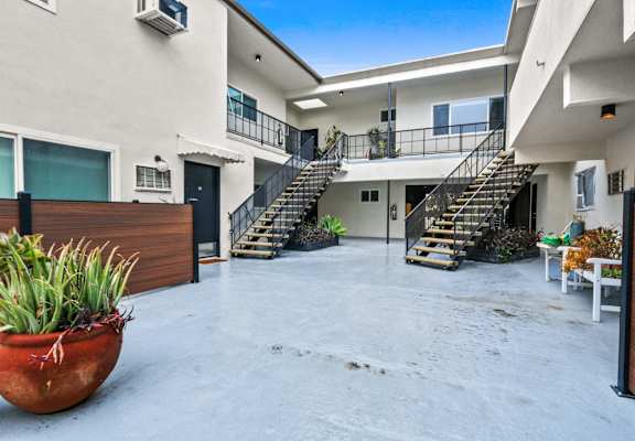 the courtyard of a building with stairs and a potted plant