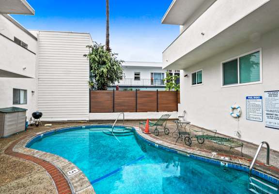 a swimming pool is next to a white house with a pool