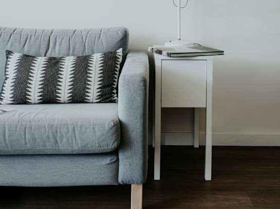 a living room with a couch and a lamp  at Pier Park Apartments, Oregon