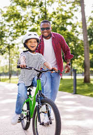 A man and a child are riding a bicycle together.