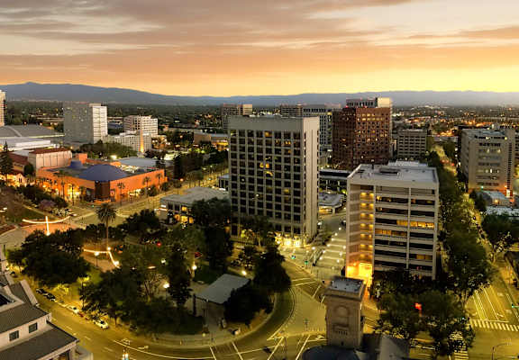 A cityscape at dusk with buildings and a pool.