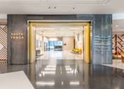 Thumbnail 7 of 24 - A hallway with a sign that says "South Tower" on the wall.