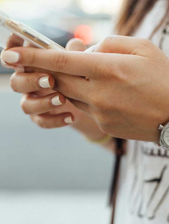 A person is holding a smartphone in their right hand.