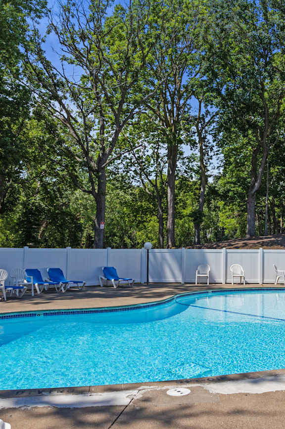 A small pool surrounded by trees and chairs at Heritage Hills Apartments, Bloomington, MN