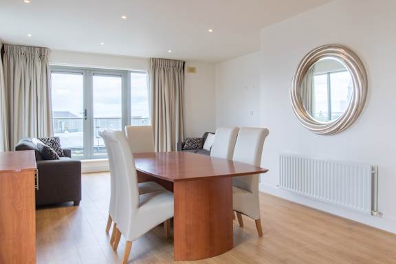 a dining room with a wooden table and white chairs
