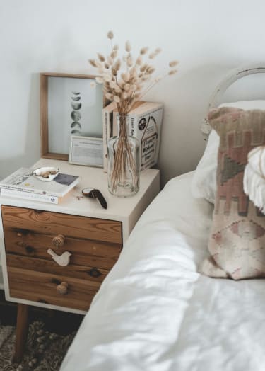 a bedroom with a bed and a nightstand with a vase of flowers at Balfour 296 in Georgia 30047