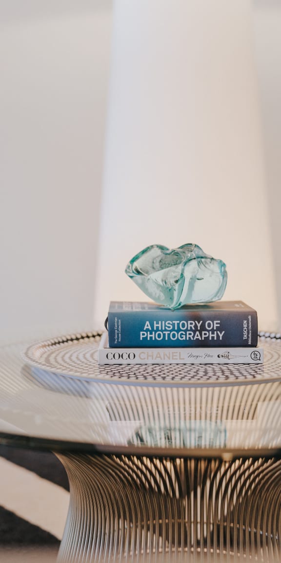 a stack of books sitting on top of a glass table